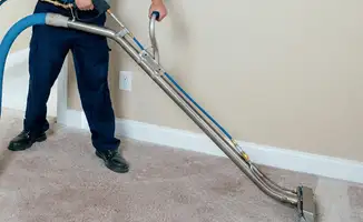 Professional operating a liquid removal machine on a carpeted floor in Tucson, AZ